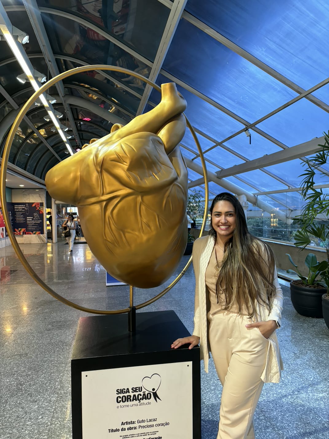 Dra. Iasmim Borges ao lado de escultura de coração